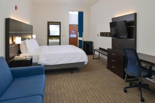 a hotel room with a bed and a desk and a tv at Holiday Inn Express Madera by IHG in Madera