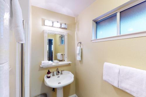 a white bathroom with a sink and a window at Calandri Lakeview House in Bass Lake