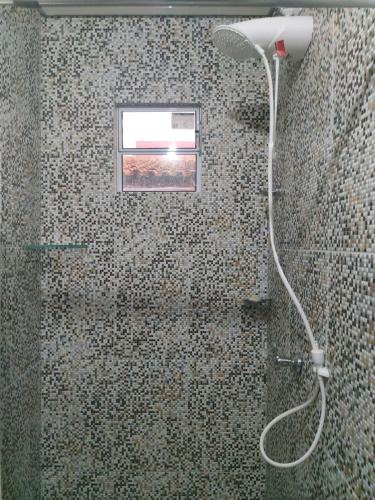 a shower in a bathroom with a window at Chalés Villa Carpe Diem in Bezerros