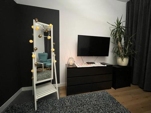 een kamer met een spiegel en een dressoir met een televisie bij Przytulny Apartament w Centrum in Częstochowa