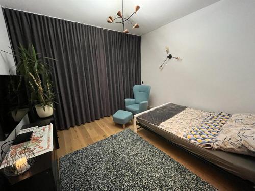 een slaapkamer met een bed, een stoel en een raam bij Przytulny Apartament w Centrum in Częstochowa