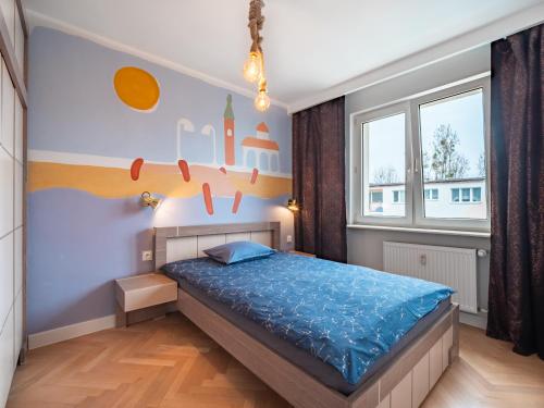 - une chambre avec un lit et une grande fenêtre dans l'établissement Apartament Bursztynowy Nowy, à Sopot