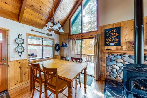 a dining room with a wooden table and a fireplace at Pine Paradise in Camp Connell
