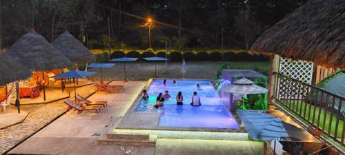 eine Gruppe von Personen in einem Schwimmbad in der Nacht in der Unterkunft QUINTA PRIMAVERA - Hostería Campestre in Nueva Loja