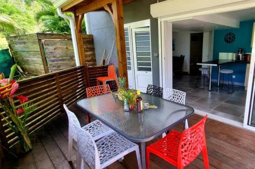 a table and chairs sitting on a porch with a table and chairsktop at Beau T2 48m2 tt confort calme 2 adultes 1 enfant in Les Trois-Îlets
