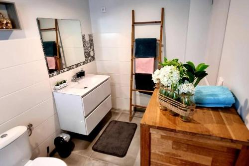 a bathroom with a sink and a counter with flowers on it at Beau T2 48m2 tt confort calme 2 adultes 1 enfant in Les Trois-Îlets