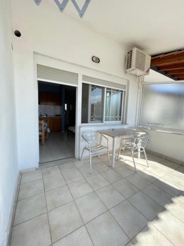 une salle à manger avec une table et des chaises sur une terrasse dans l'établissement Artemis Hotel Apartments, à Keramoti