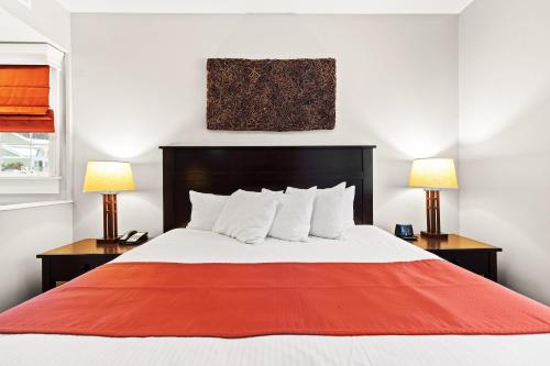 a bedroom with a large bed with two lamps at Club Wyndham Shawnee Village in East Stroudsburg