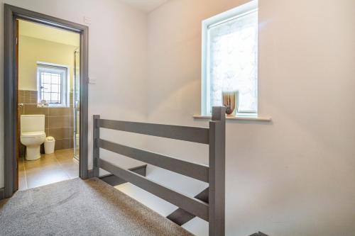 a bathroom with a toilet and a window at Corner Cottage in Bakewell