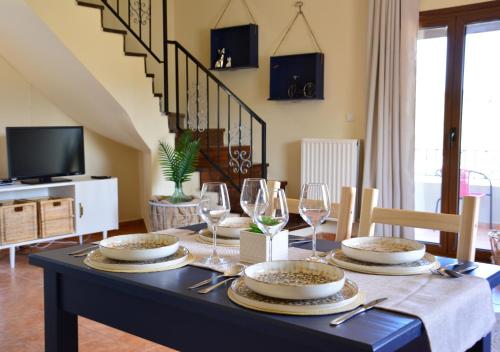 a dining room with a table with plates and wine glasses at Elianthos Villas in Vamos