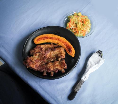 a plate of food with a piece of meat and a carrot at Finca Ecoturistica LOS JAGUEYES in Baraya