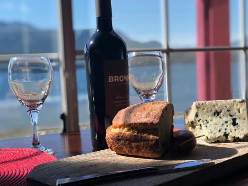 a bottle of wine and two glasses on a table with bread at Alert Bay Lodge in Alert Bay