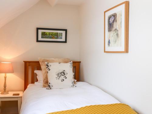 a bedroom with a white bed and two pictures on the wall at Church House in Matlock