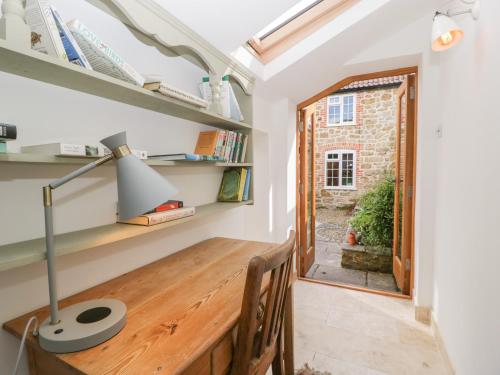 una oficina con escritorio de madera y ventana en Bonnings Cottage, en Ilminster