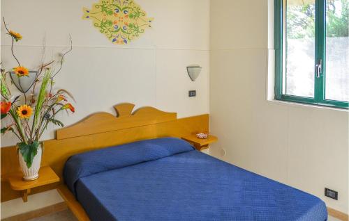una camera con letto blu e vaso con fiori di Alessidamo Bilo a Metaponto