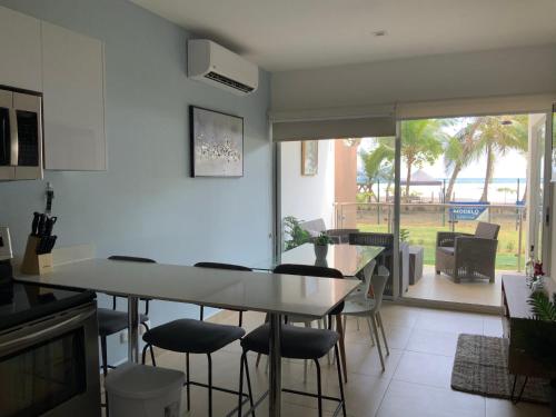 a kitchen with a table and chairs in a room at Bejuco Beachfront Condo FRENTE A LA PLAYA hermoso condominio NUEVO in Esterillos Este