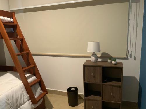 a bedroom with two bunk beds and a table with a lamp at Bejuco Beachfront Condo FRENTE A LA PLAYA hermoso condominio NUEVO in Esterillos Este