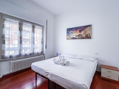 a white bedroom with a bed and a window at MYHOUSE INN PORTA NUOVA - Affitti Brevi Italia in Turin