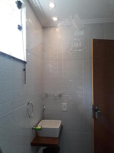 ein weißes Badezimmer mit Waschbecken und Dusche in der Unterkunft Chalé Privilégio in Rio Prêto