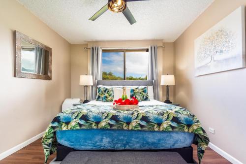 een slaapkamer met een bed en een blauwe bank bij Kahana Manor 418 condo in Kahana