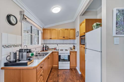 a kitchen with wooden cabinets and a white refrigerator at Diamondvale Estate Stanthorpe in Stanthorpe