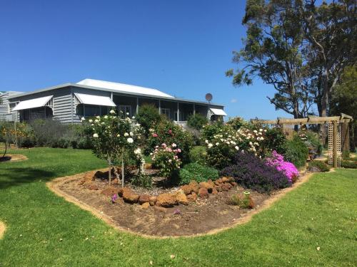 a garden with flowers in front of a house at The Grange on Kalgan Farmstay, Albany WA in Albany