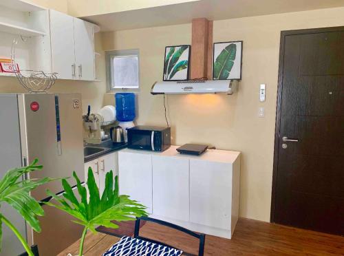 una pequeña cocina con armarios blancos y una planta en *NEW* 2-Bedroom PENTHOUSE Condo Unit Centrio Tower(beside Ayala Centrio Mall) Downtown CDOC, en Cagayan de Oro