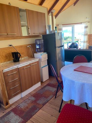a kitchen with a table and a refrigerator at Ventisca Sur in Coihaique