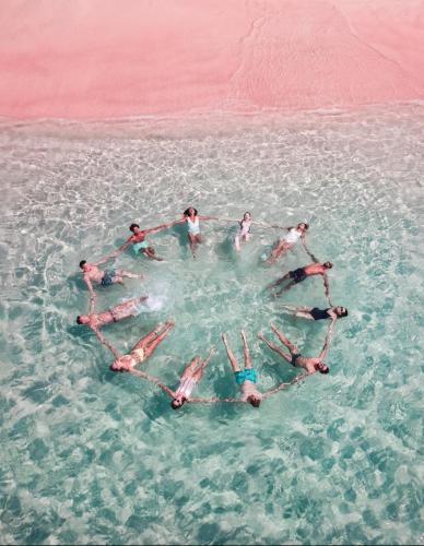a group of people in a circle in the water at Beachfront Paradise in Manuel Antonio