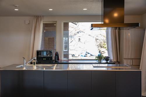 a kitchen with a sink and a large window at HANA TOYA in Lake Toya