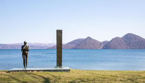 a statue of a woman standing next to a body of water at HANA TOYA in Lake Toya