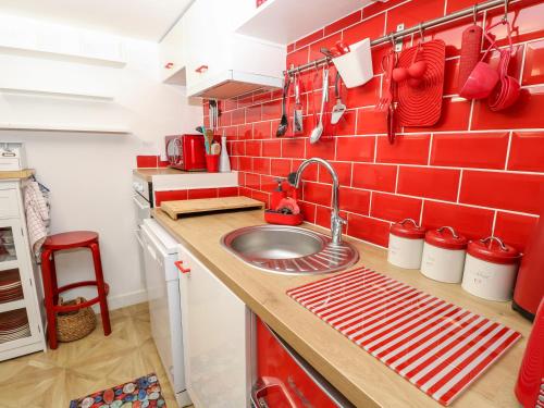 a kitchen with a sink and a red brick wall at White Haven in Sandown