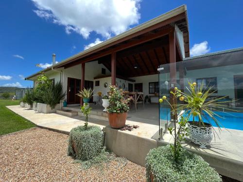 a house with plants in front of it at Blue Fattoria Luxury Farm Accomodation in Fernside