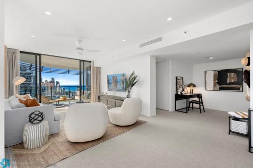 a living room with white furniture and a large window at Oracle Resort Broadbeach - gclr in Gold Coast