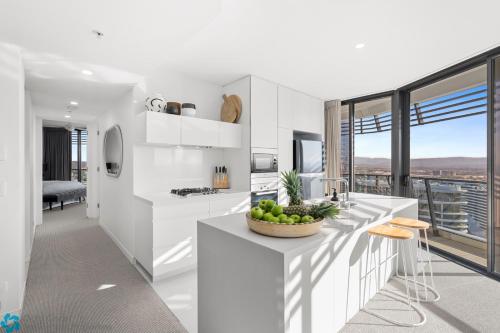 a white kitchen with a bowl of fruit on a counter at Oracle Resort Broadbeach - gclr in Gold Coast