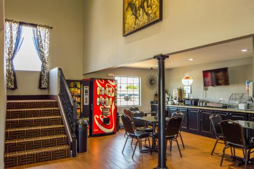 a restaurant with a soda machine and a table and chairs at Super 8 by Wyndham Ardmore in Ardmore