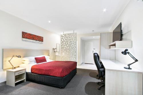 a bedroom with a bed and a desk with a computer at The Aspen & Apartments in Sale