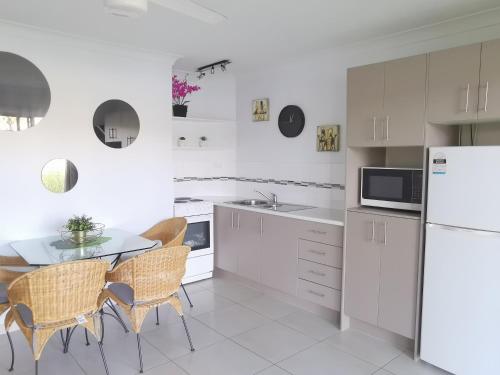 a kitchen with white appliances and a table and chairs at Bay of Palms in Gold Coast