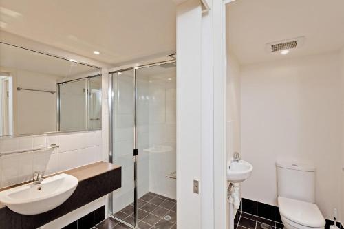 a white bathroom with a sink and a toilet at Baden 74 Rainbow Shores in Rainbow Beach