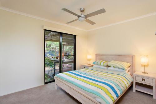 a bedroom with a bed and a ceiling fan at 6 Orania Court Rainbow Shores in Rainbow Beach