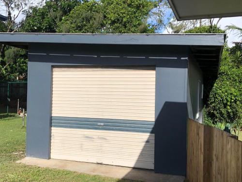 a garage with a blue and white garage door at 9 Indigo Avenue Rainbow Beach in Rainbow Beach