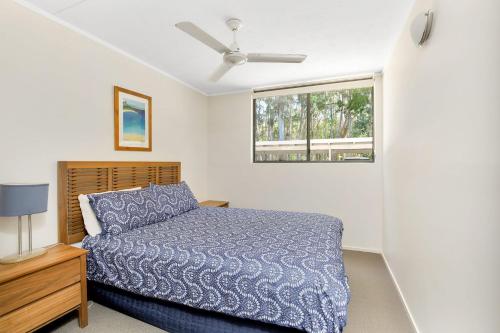 a bedroom with a bed and a window at Baden 52 Rainbow Shores in Rainbow Beach