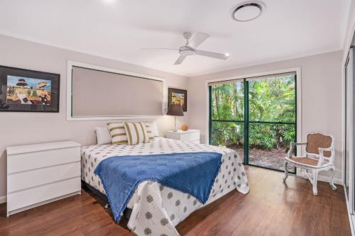 a bedroom with a bed and a large window at 7 Belle Court Rainbow Shores Fully ducted aircon. Pets welcome in Rainbow Beach