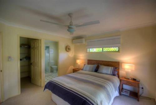 a bedroom with a large bed and a window at 4 Boronia Place Rainbow Beach in Rainbow Beach