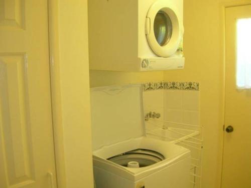 a bathroom with a toilet in the corner of a room at 4 Boronia Place Rainbow Beach in Rainbow Beach