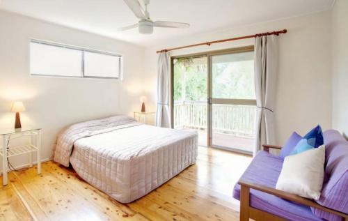 a bedroom with a bed and a couch at 33 Cooloola Drive Rainbow Beach in Rainbow Beach