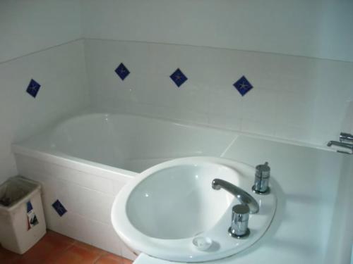 a white sink in a bathroom with blue tiles on the wall at 43 Satinwood Drive Rainbow Shores in Rainbow Beach