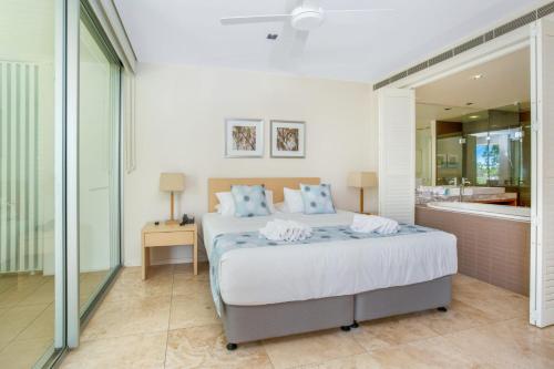 - une chambre avec un lit et une baignoire dans l'établissement Unit 8 Plantation Resort Rainbow Beach, à Rainbow Beach