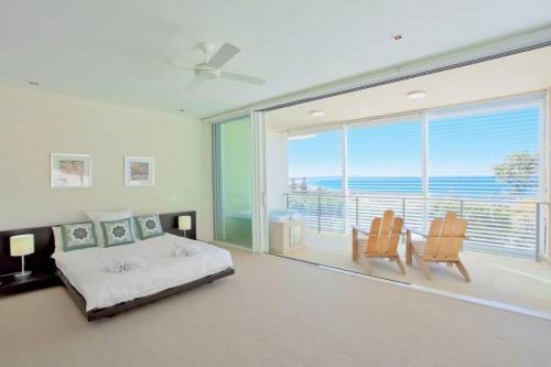 a bedroom with a bed and a large window at Ocean View 1 Rainbow Beach in Rainbow Beach