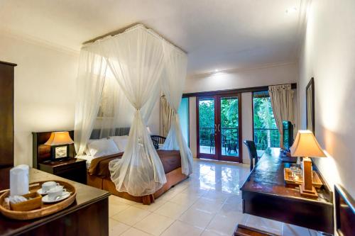 a bedroom with a bed with mosquito net at Champlung Sari Hotel and Spa Ubud in Ubud